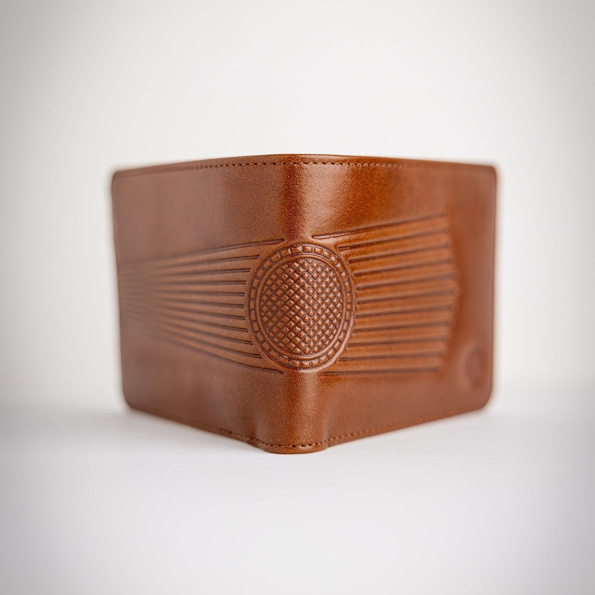 Brown leather wallet with embossed design on a light gray background